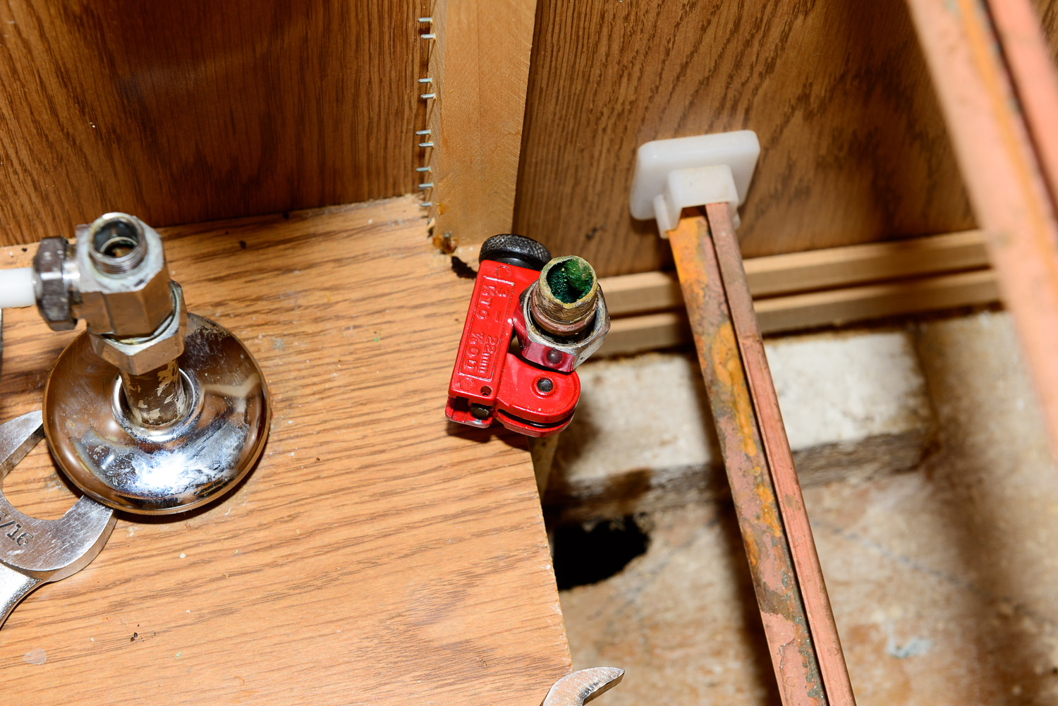 I used a small tubing cutter in the inside of the cabinet because there wasn't any room to rotate the larger one.  Of course you can always use a hacksaw.