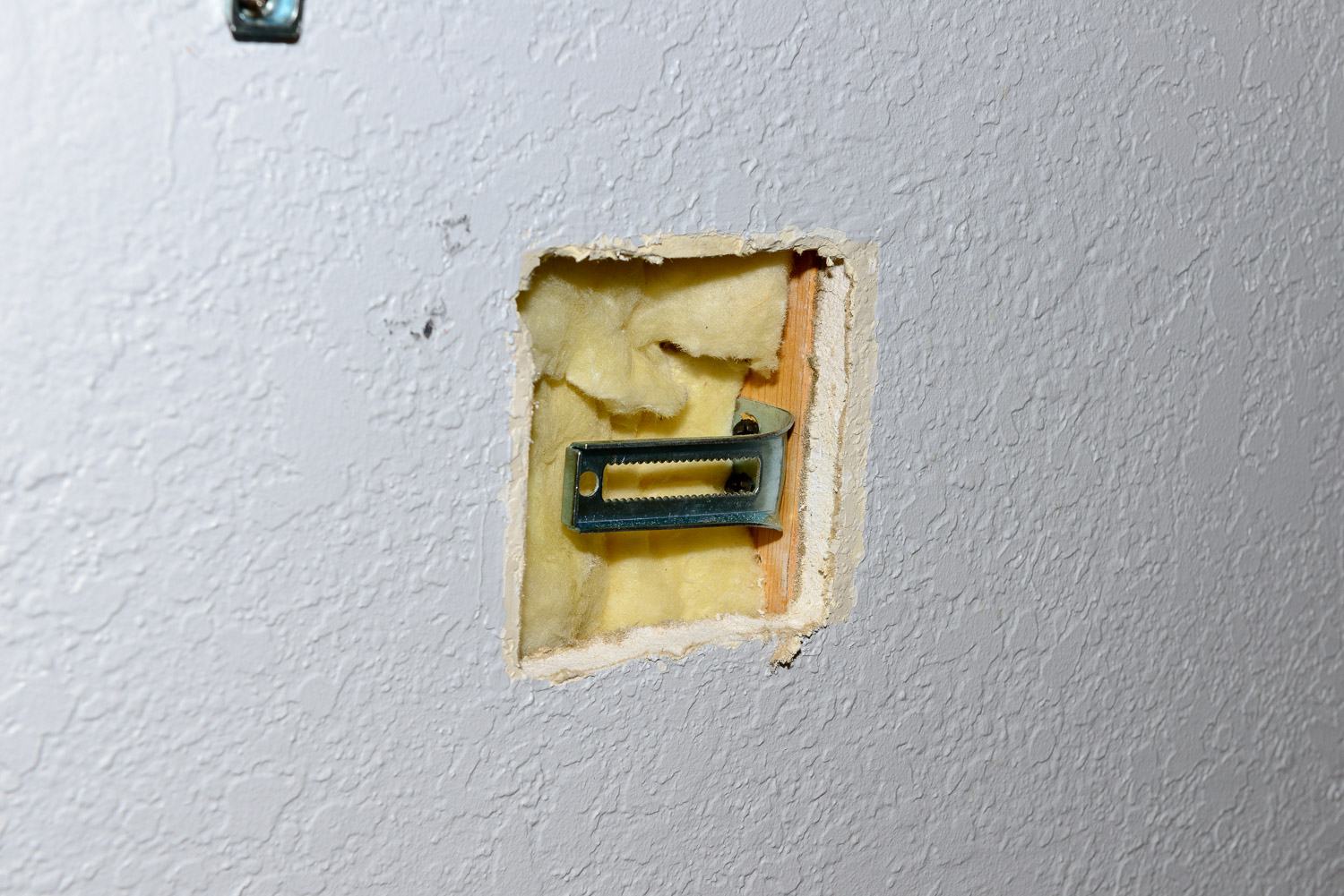 I'm going to patch the hole in the wall for the old whirlpool control.  I like to have some kind of backer to keep the patch from pushing back into the wall.  I happened to have an old bracket for a bifold door laying around. I screwed it in with a couple of drywall screws