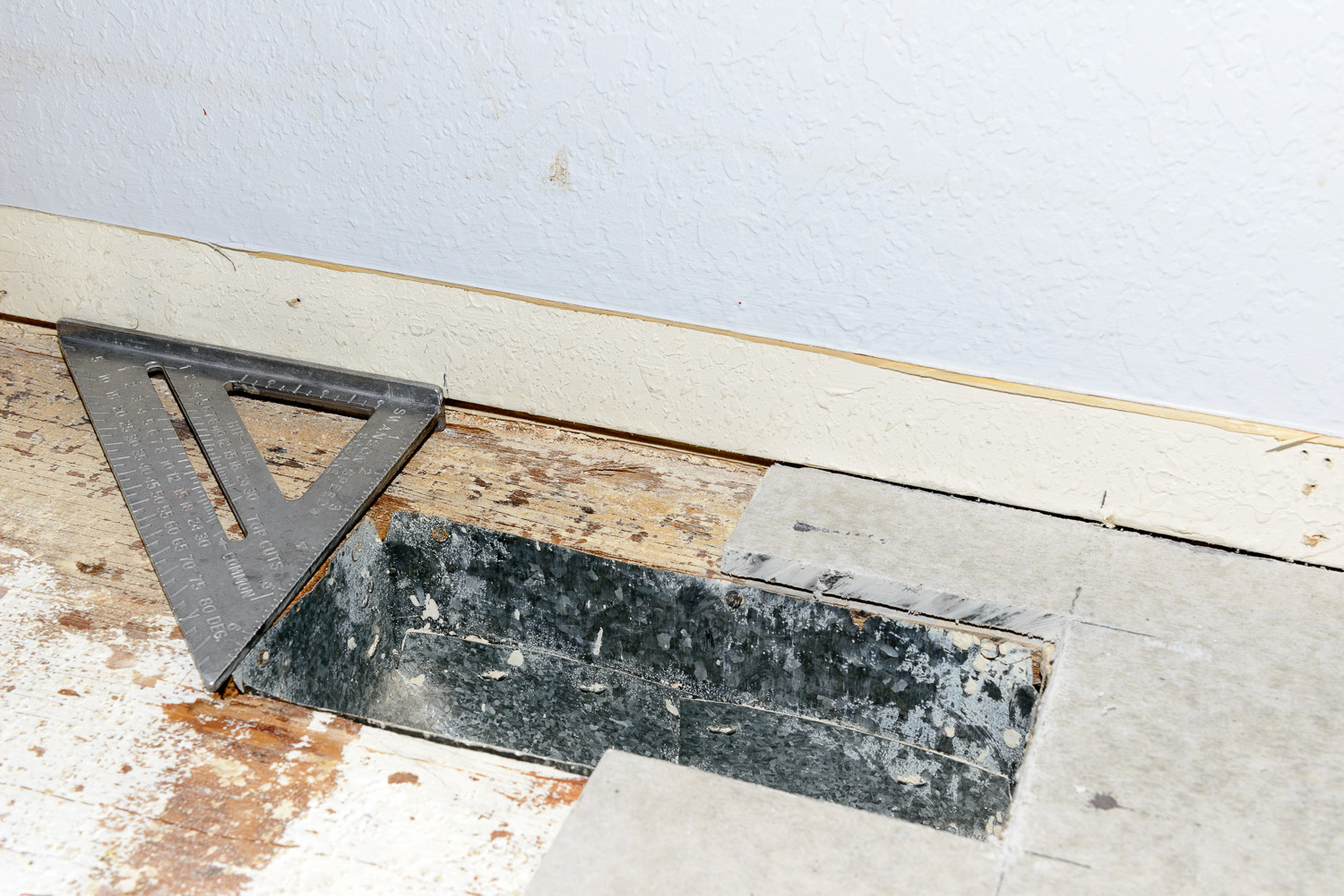 Mark the wall at the end of the vent so you know how far to cut. When you put the board down you won't see the vent