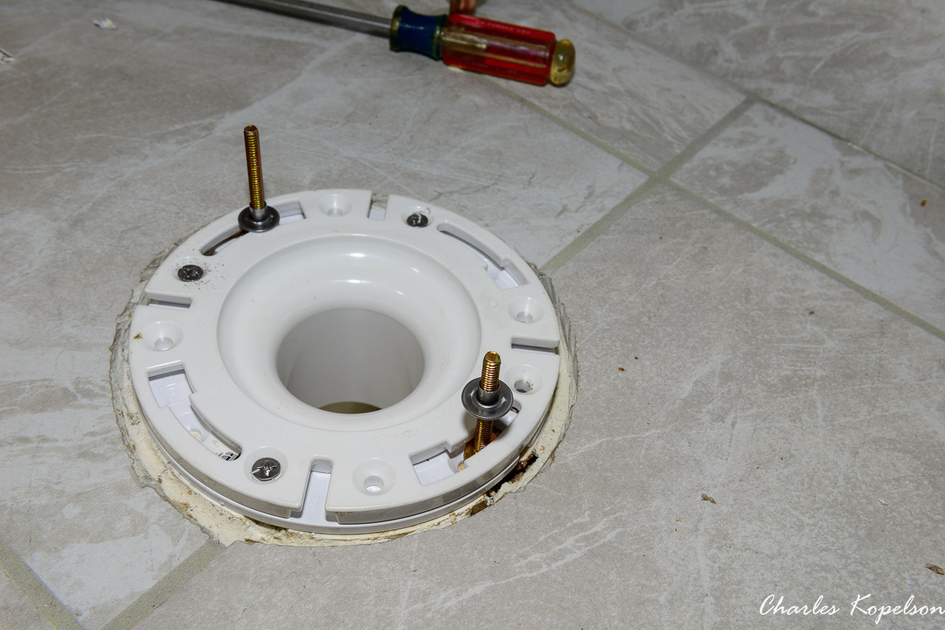 I slid the T bolts into the slots in the flange at the 3 o'clock and 9 o'clock positions. This Champion toilet came with retainer nuts which is a great feature.  It keeps the bolts sticking straight up when you lower the toilet onto the flange.