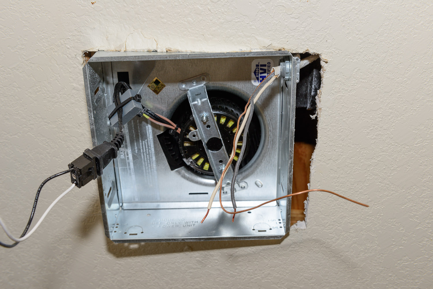 Push the fan up into place and feed the romex into the connector